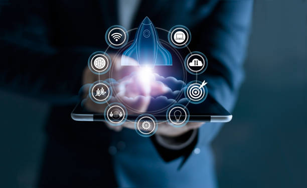 istock Startup concept. Businessman touching tablet and icon network connection with rocket flying out of screen on dark background 928166838