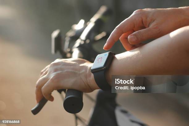 Woman Cyclist Hands With Heart Rate Icon On Smart Watch Bicycle At Summer Trail All On Screen Are Design Up Stock Photo - Download Image Now