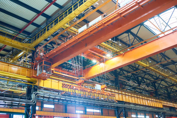 Large modern construction factory with overhead cranes Modern factory design: reliable framed ceiling construction with powerful overhead crane crane construction machinery stock pictures, royalty-free photos & images