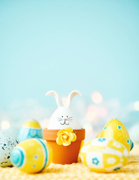 Easter background with baby rabbit and yellow and blue Easter eggs