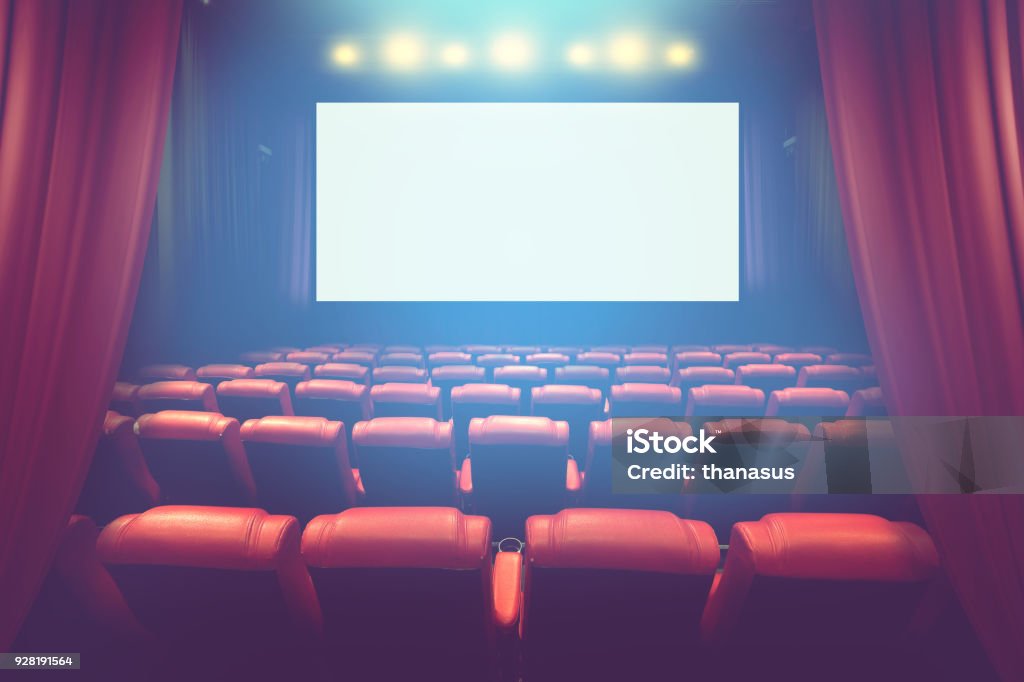 empty theater auditorium with blank screen or movie cinema with red seats before show time Movie Theater Stock Photo