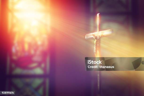 Kruzifix Jesus Am Kreuz In Der Kirche Mit Lichtstrahl Aus Buntglas Stockfoto und mehr Bilder von Katholizismus