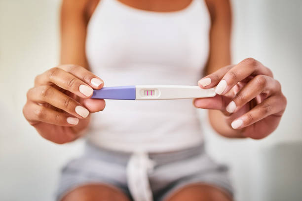 Someone's about to be a mom Cropped shot of a woman taking a pregnancy test while sitting on the toilet family planning stock pictures, royalty-free photos & images