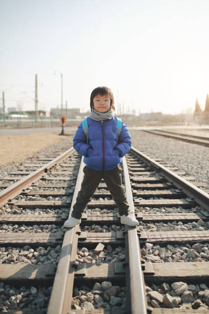 Man waiting for a train on multiple railroad tracks station