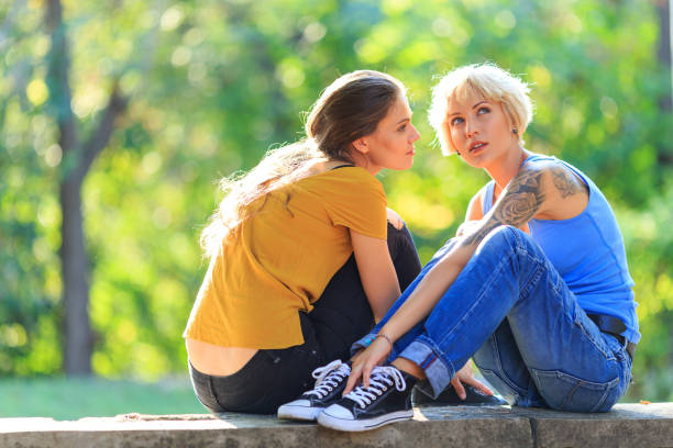istock Two friends sitting in park 928209516