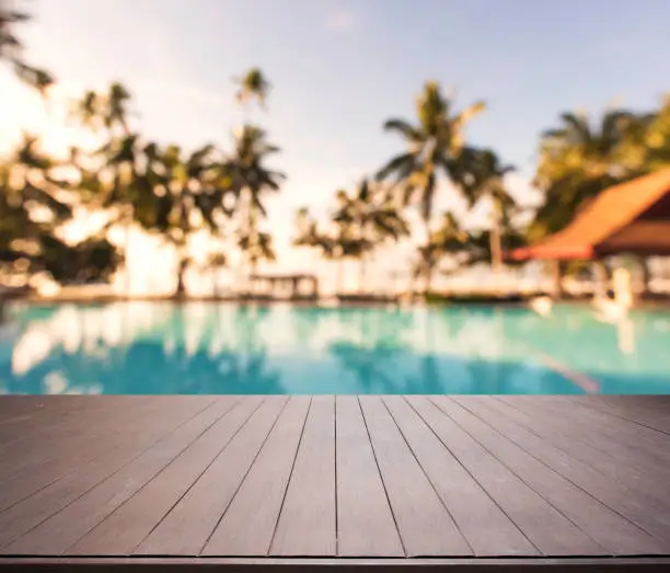Wooden terrace beside tropical swimming pool