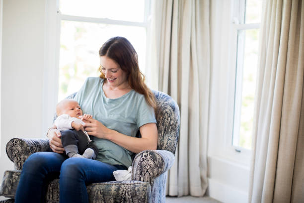 istock Smiling mother playing with baby boy on sofa 928214622