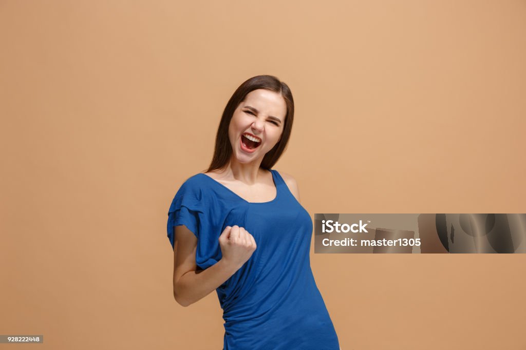 Winning success woman happy ecstatic celebrating being a winner. Dynamic energetic image of female model I won. Winning success happy woman celebrating being a winner. Dynamic image of caucasian female model on pastel studio background. Victory, delight concept. Human facial emotions concept. Trendy colors Women Stock Photo