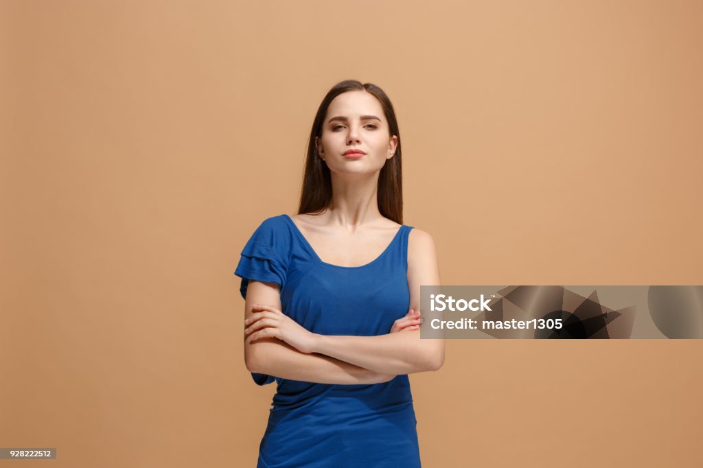 The serious woman standing and looking at camera against pastel background Serious woman standing, looking at camera isolated on trendy pastel studio background. Beautiful, young face. Female half-length portrait. Human emotions, facial expression concept. Front Adult Stock Photo