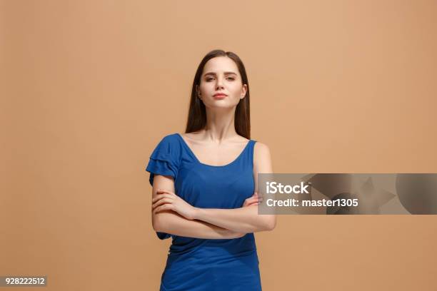 The Serious Woman Standing And Looking At Camera Against Pastel Background Stock Photo - Download Image Now