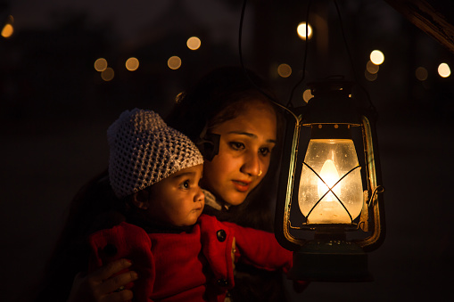 Mother with daughter hanging lantern on tree