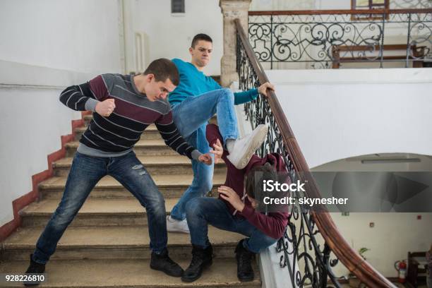 Furious Teenage Boys Bullying Their Classmate In A High School Hallway Stock Photo - Download Image Now