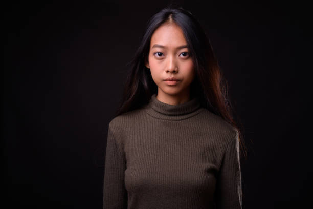 beautiful asian woman against black background - serious women asian ethnicity human face imagens e fotografias de stock