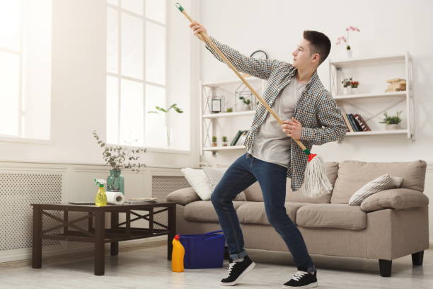 istock Young man cleaning home, playing with mop 928229748