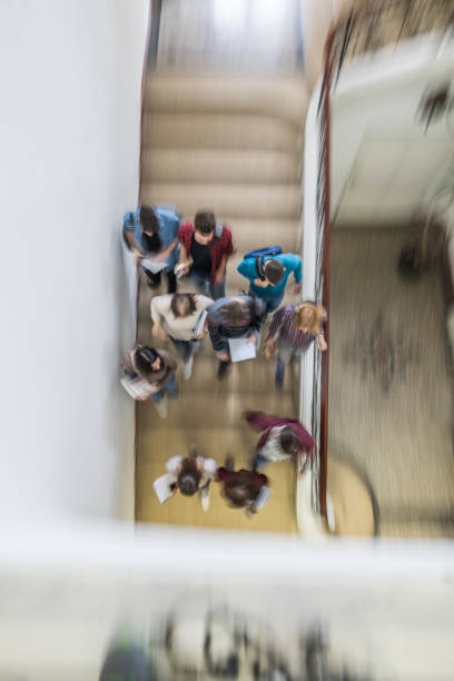 istock Above view of students walking down the stairs in blurred motion. 928231610