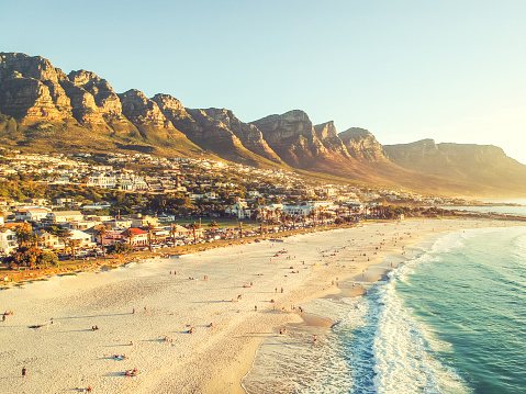 Stunning wide angle aerial drone evening view of Camps Bay, an affluent suburb of Cape Town, Western Cape, South Africa. Twelve apostles mountain range in the background. Photo cross processed.
