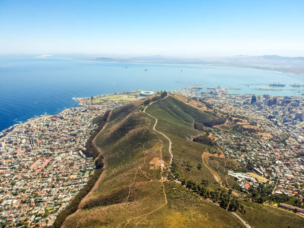 magnifique vue aérienne drone grande-angulaire de signal hill et la banlieue de mouille point et point vert avec le stade vu de dessus du sommet de la montagne de tête de lion à cape town, afrique du sud. - victoria and alfred photos et images de collection