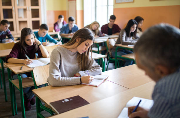 istock Group of high school students writing a test in the classroom. 928235500