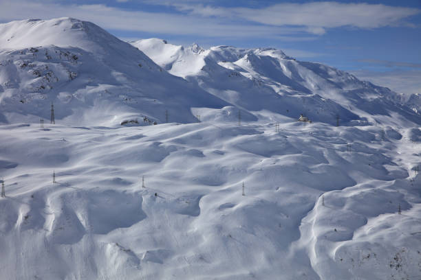 Aerial view of the small village of Zürs in the skiresort of St. Anton am Arlberg on a sunny day with snowcovered mountainrange in the background in the Arlberg Alps in Austria. Zürs and Lech am Arlberg is a highend luxury and exclusive skiresort that attracts wealthy families.