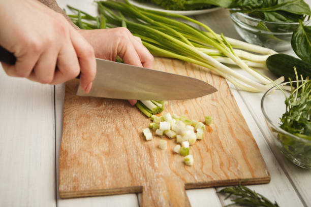 istock Woman cutting spring onion for salad 928240058