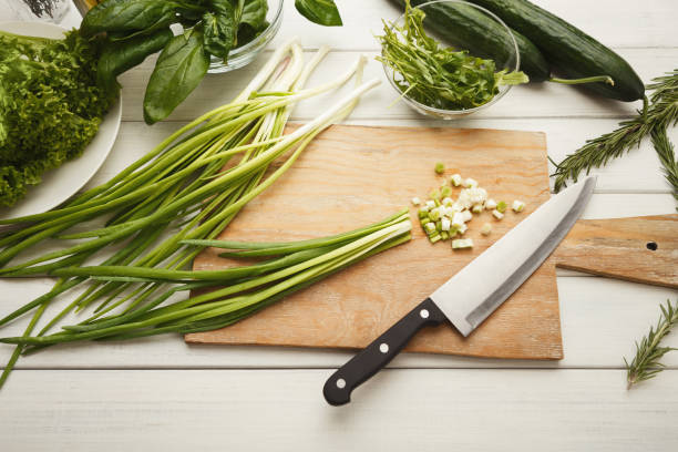 istock Cutting spring onion for fresh salad top view 928240084