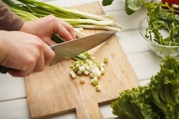 istock Woman cutting spring onion for salad 928240124