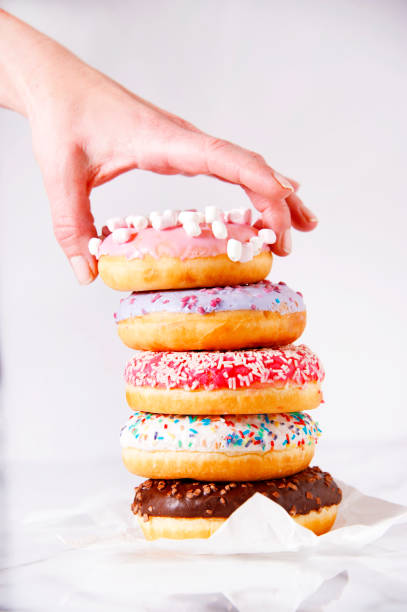 istock Woman's hand is swiping one from a pile of donuts. 928242076