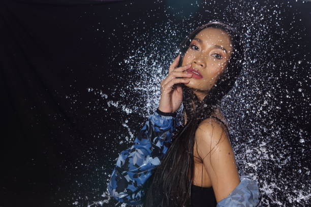 istock Active Woman rain coat with Water Splash over studio lighting black backgrounds 928243590