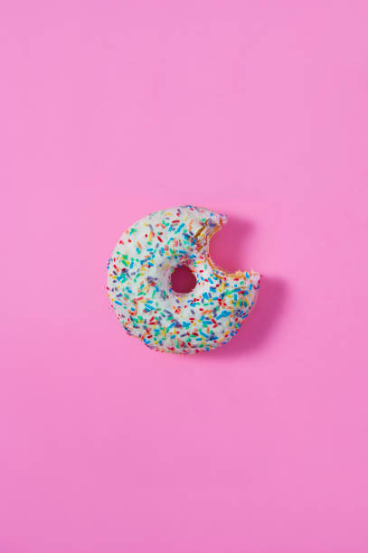 istock A bagel with a bite on pink isolated background. 928246372