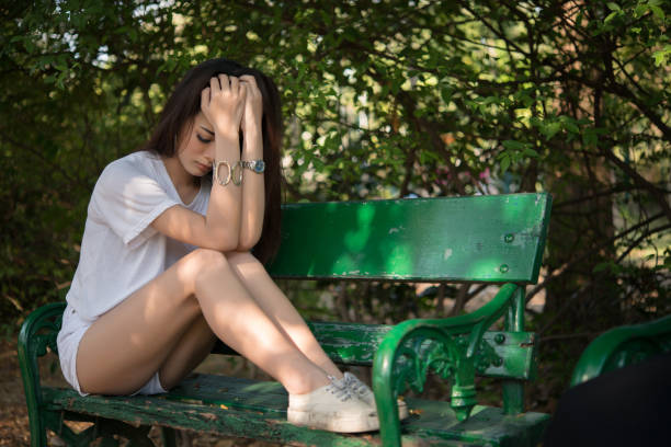 istock Sad loneliness woman sitting on a bench alone at park. 928246470