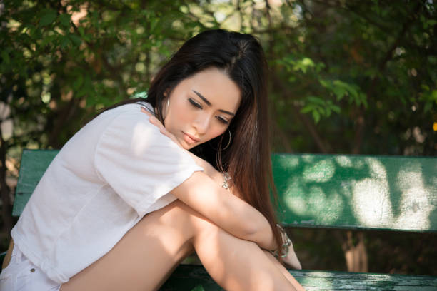 istock Sad loneliness woman sitting on a bench alone at park. 928246722