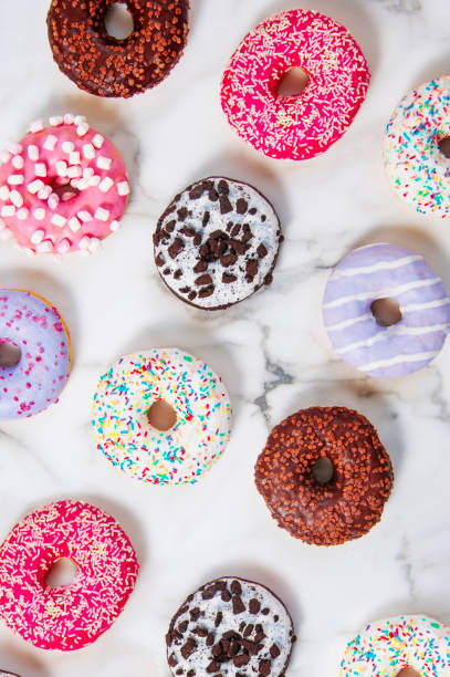 Various donuts on a marble pattern background. stock photo