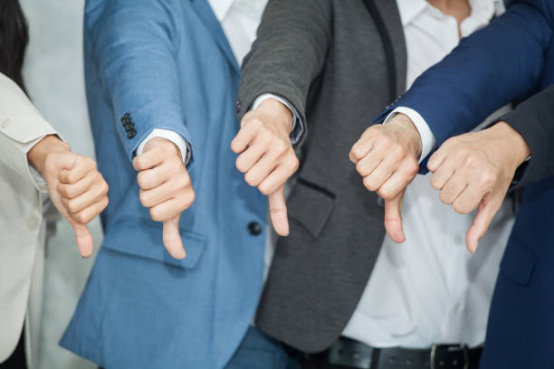 Group of Business manThumbs Down To failing to work without a teamwork No understanding Cause job failure.show dislike or unlike stock photo
