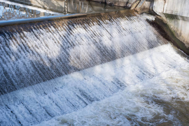 istock Water falls from a height of city river gateway 928250982