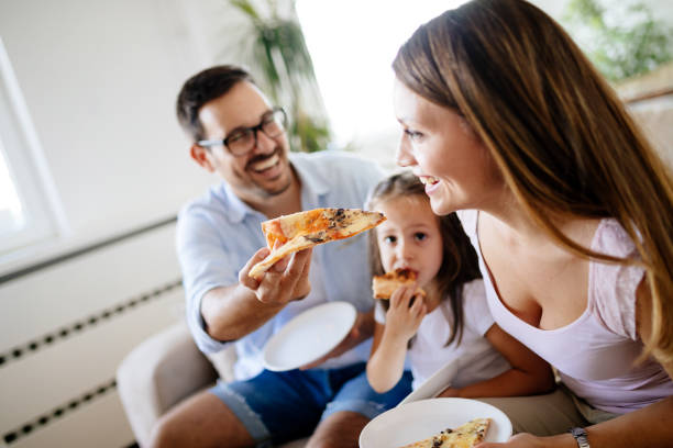 istock Happy family sharing pizza together at home 928254714