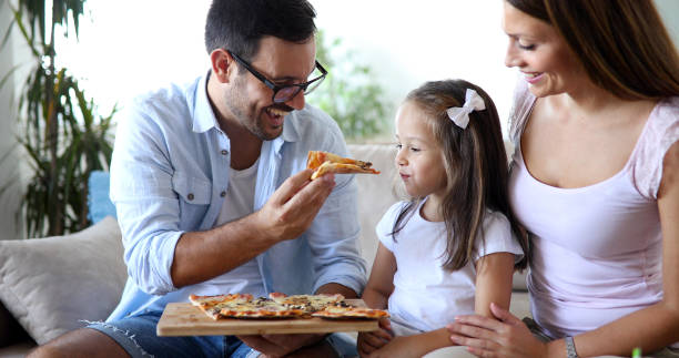 istock Happy family sharing pizza together at home 928255292