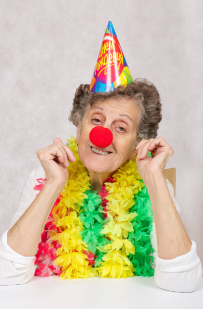 80歳の先輩女性は誕生日パーティーの準備ができています。ロシア語からのコーン翻訳で:「誕生日おめでとう」。 - female 80 plus years vertical people ストックフォトと画像