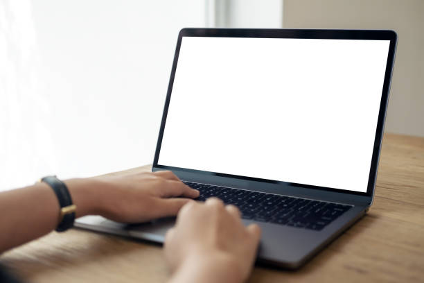 istock Mockup image of hands using and typing on laptop with blank white desktop screen on wooden table 928268012