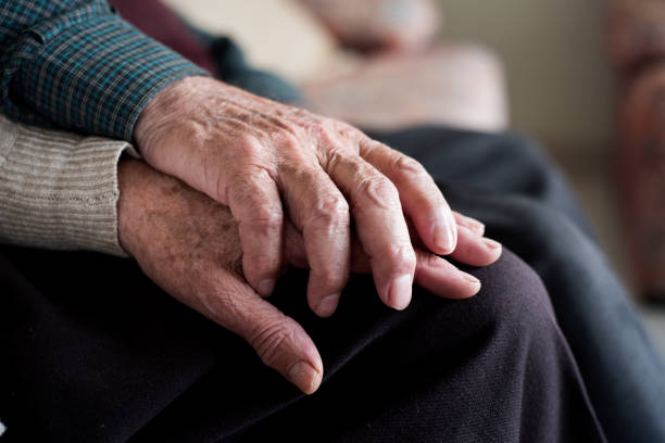 hombre y mujer tomados de la mano - sofa men adult aging process fotografías e imágenes de stock