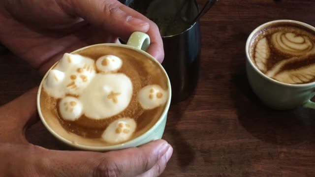 barista create latte art on wooden table