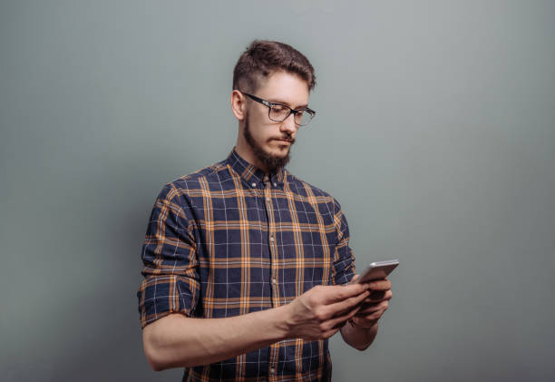 istock Serious young man typing message on the phone 928280282
