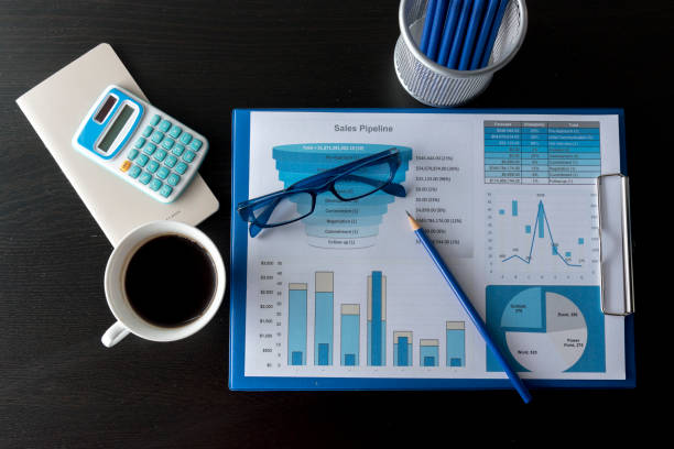 istock Business stuff, Graph, charts, calculator, glasses , pen and a cup of coffee. 928296976