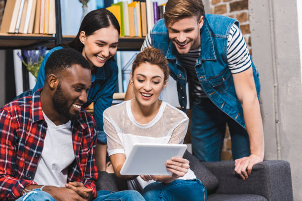 istock happy young multiethnic friends using digital tablet together 928300790