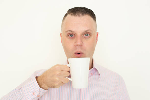 istock Serious businessman blowing to cool coffee 928301402