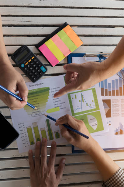istock Top view of young working woman using laptop and reading report , graphs , charts, document at work. Business woman working at her desk. 928301718