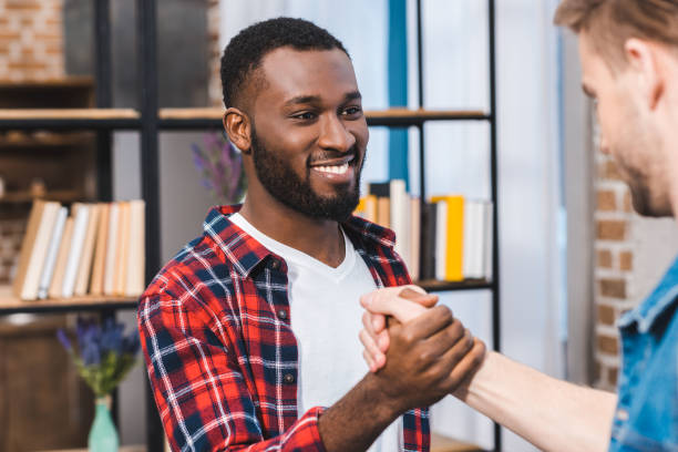 istock selective focus of young multiethnic men holding hands and smiling each other 928306572