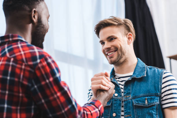 istock selective focus of young multiethnic men smiling each other 928306670