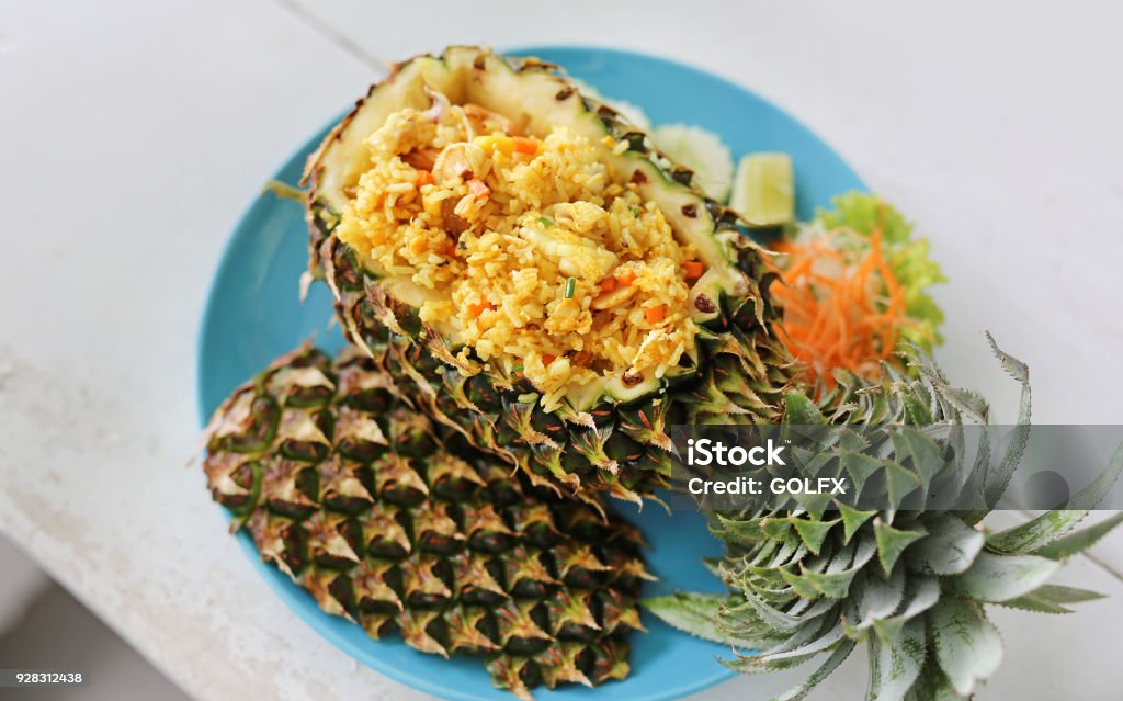 Prepared pineapple fried rice served inside of a pineapple carved like a bowl. Asia Stock Photo