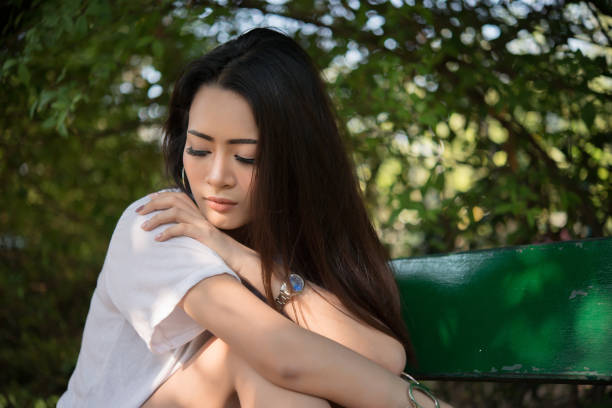 istock Sad loneliness woman sitting on a bench alone at park. 928314840