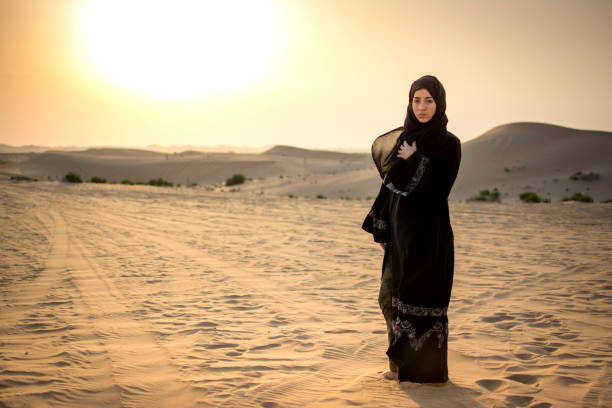 istock Arab woman standing in the desert during sunset. 928315120